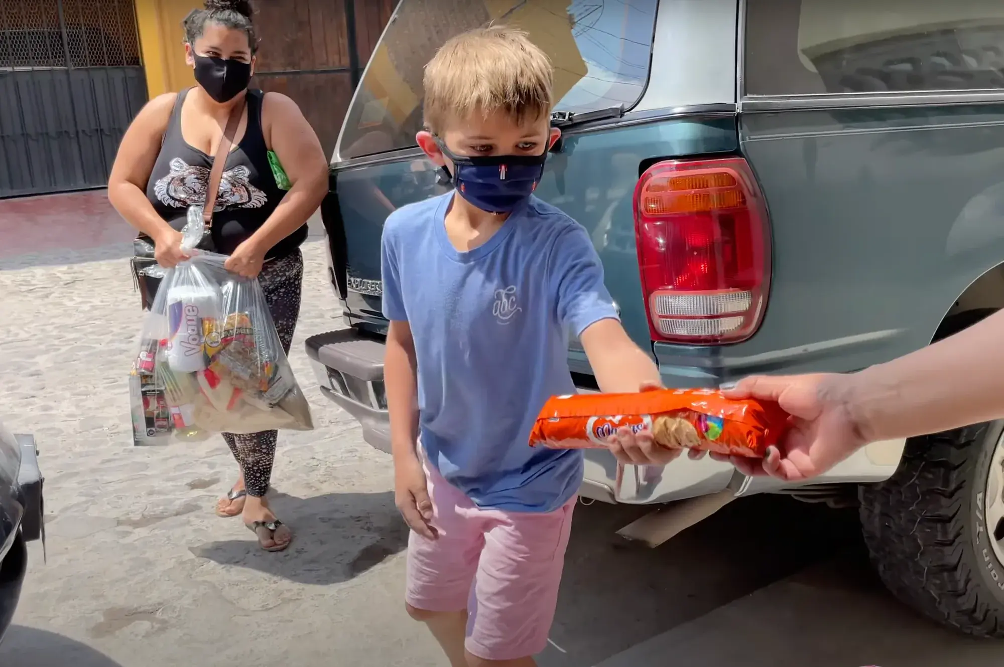 Colt Lockwood hands a food package to a neighbor in San Miguel de Allende