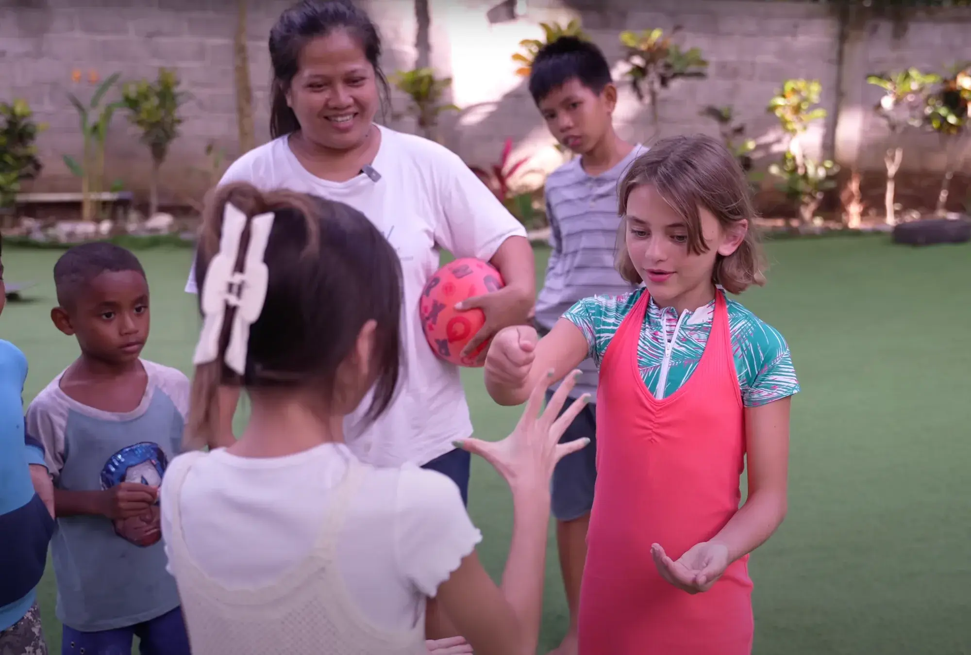 Brooklyn Lockwood plays a hand game with children at Bali Life Foundation in Uluwatu