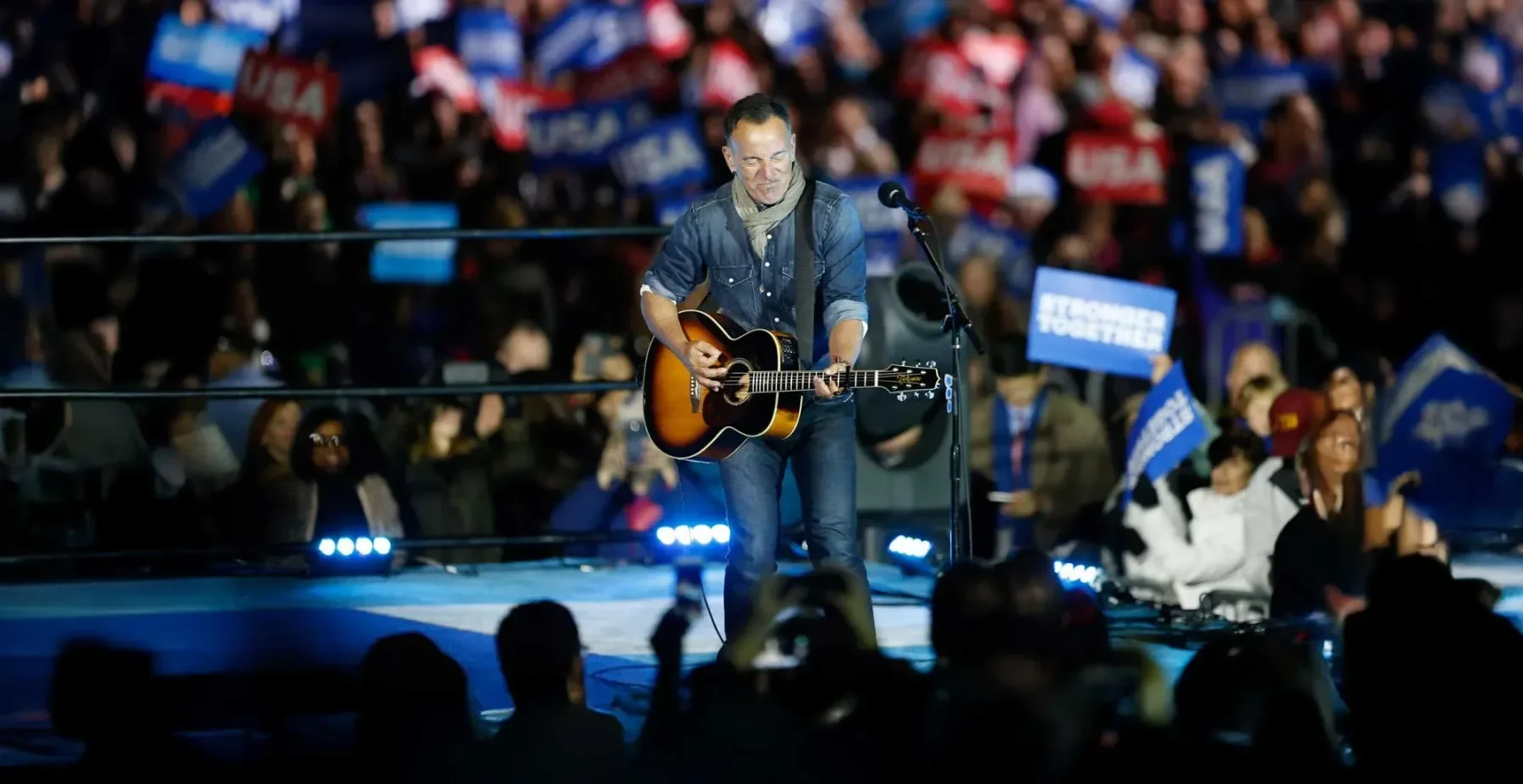 Bruce Springsteen playing guitar for an arena crowd