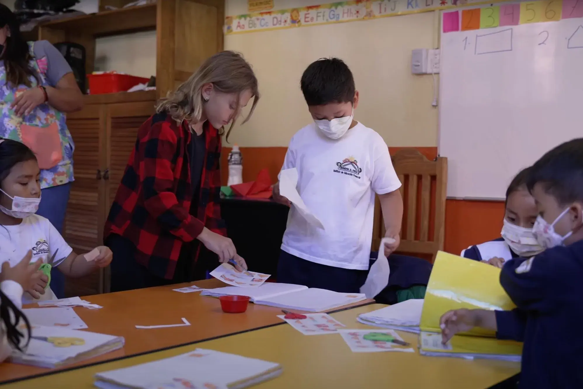 Brooklyn Lockwood hands out worksheets to preschoolers at Centro Infantil in San Miguel de Allende