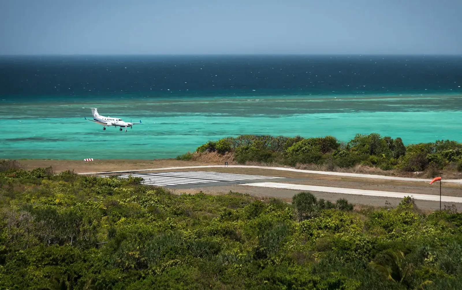 A small plane lands on the runway at Amanpulo resort
