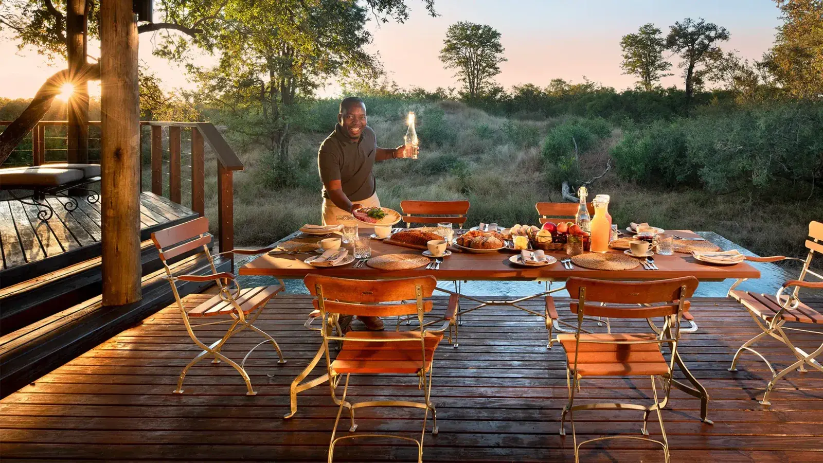 A server sets up dinner al fresco at &Beyond Ngala Safari Lodge