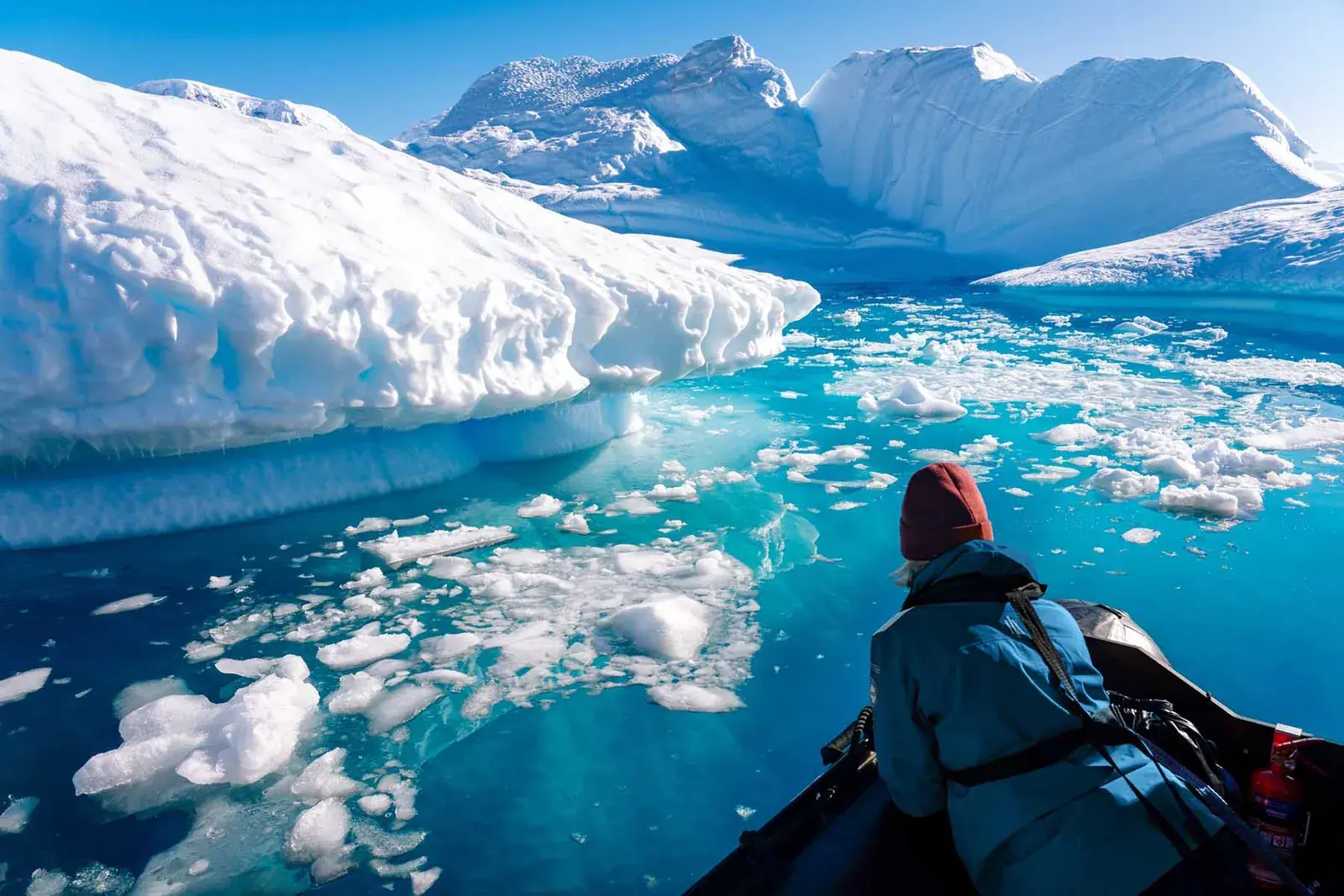 Passenger looks at icebergs from bow of hx expeditions ms roald amundsen