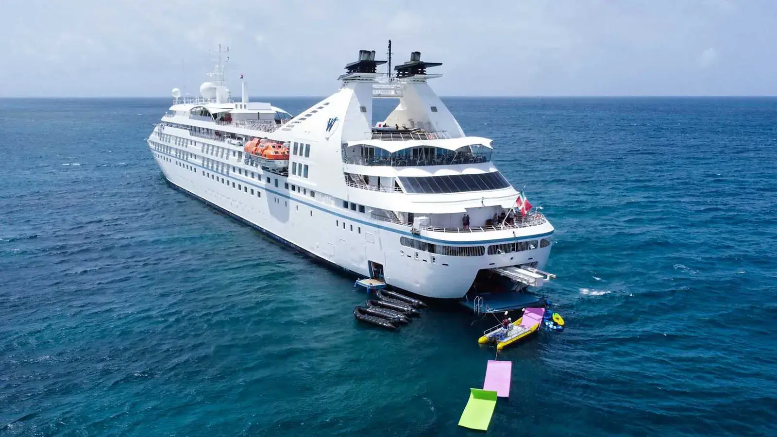 Aerial aft view of Windstar Star Breeze sailing through tropical blue waters