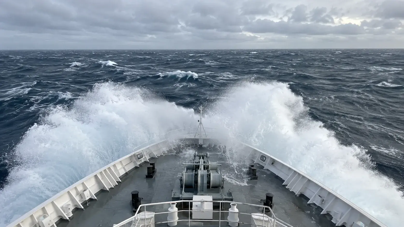 The bow of an expedition ship plowing through heavy seas in the Drake Passage
