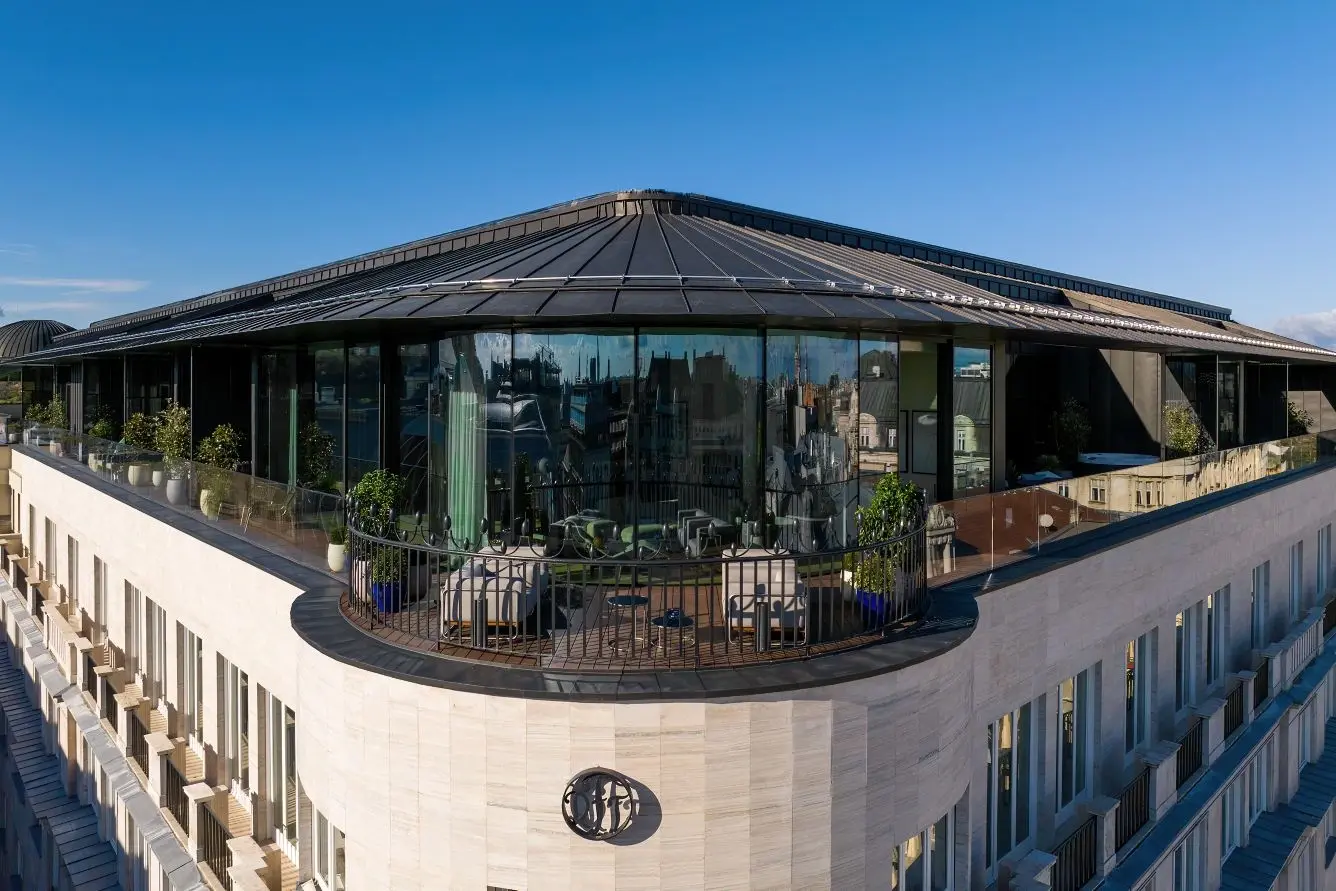 The glass-walled rooftop and curved terrace of the Dorothea Hotel in Budapest