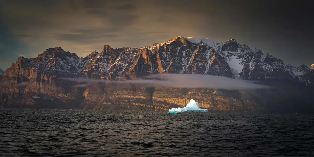 A sunset view of a mountainous coast in Greenland