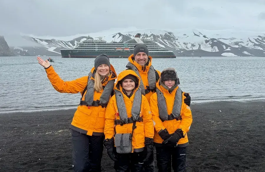 The Lockwood family poses on the shores of Deception Island in Antarctica
