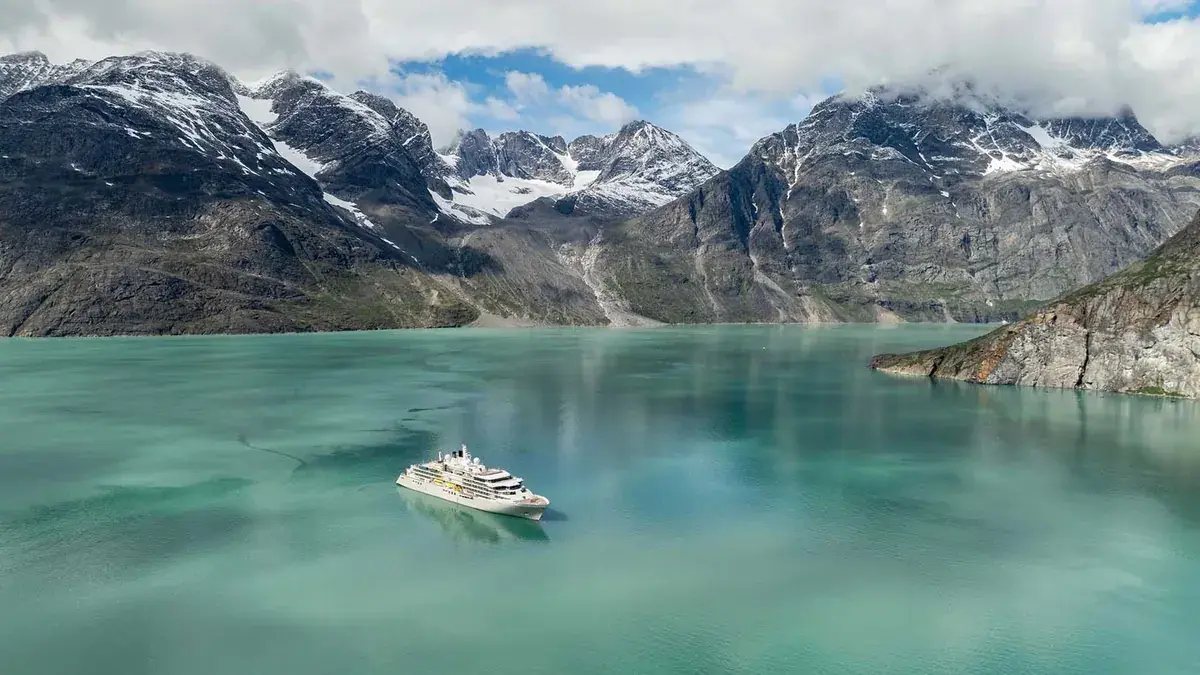 A Silversea cruise ship sits in an Alaskan harbor (aerial view)