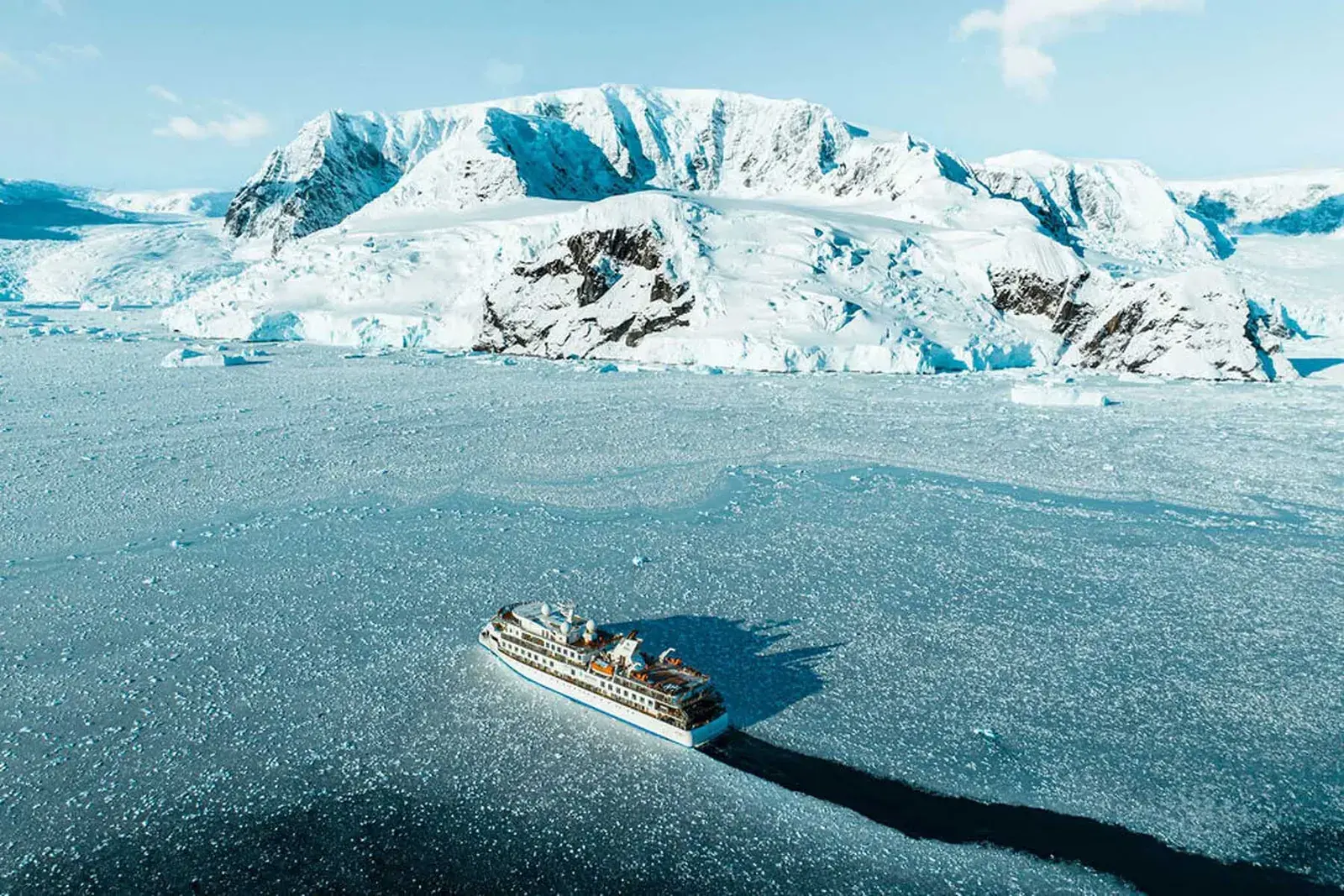 Aurora Expeditions cruise ship cutting through an icy harbor
