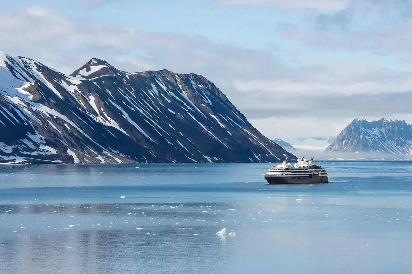 A Ponant cruise ship sails past polar landscapes