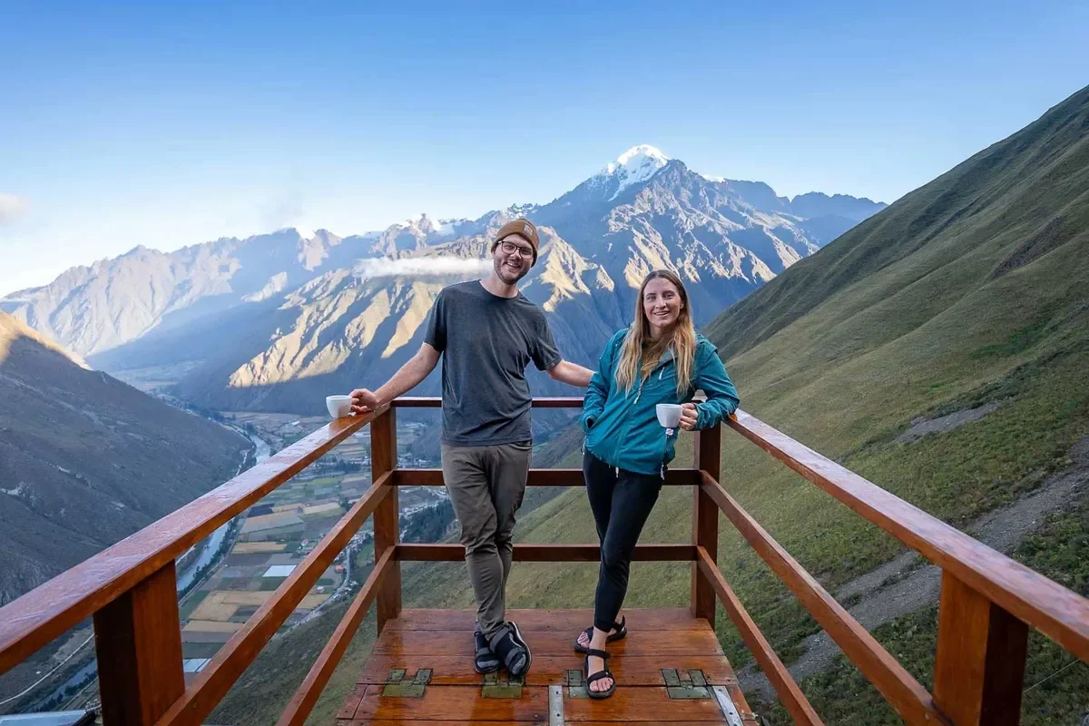 Jess and Justin of Uprooted Traveler stand in front of a mountain backdrop