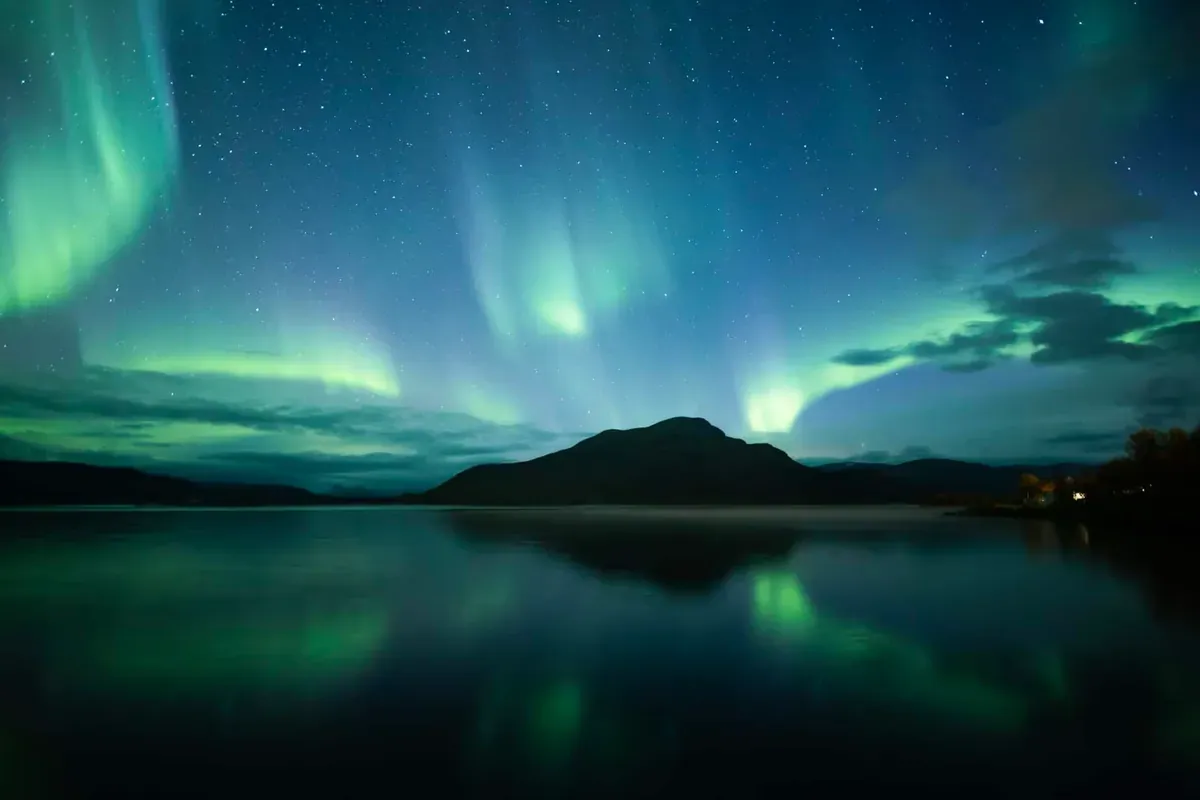 Northern lights in the sky over water of Lapland