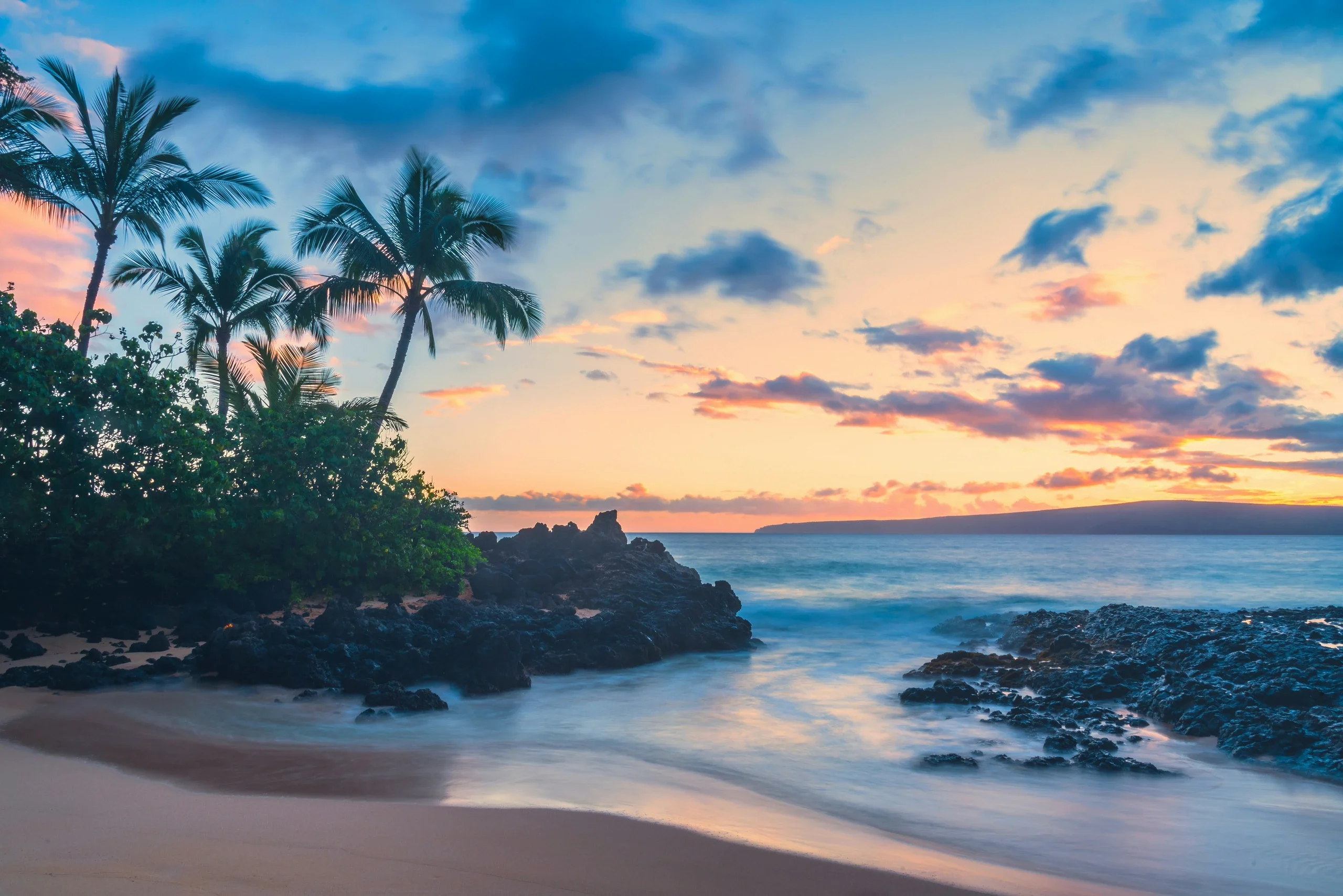 Sunset at Makena Cove, Maui: palms, black lava rock and a soft shore break