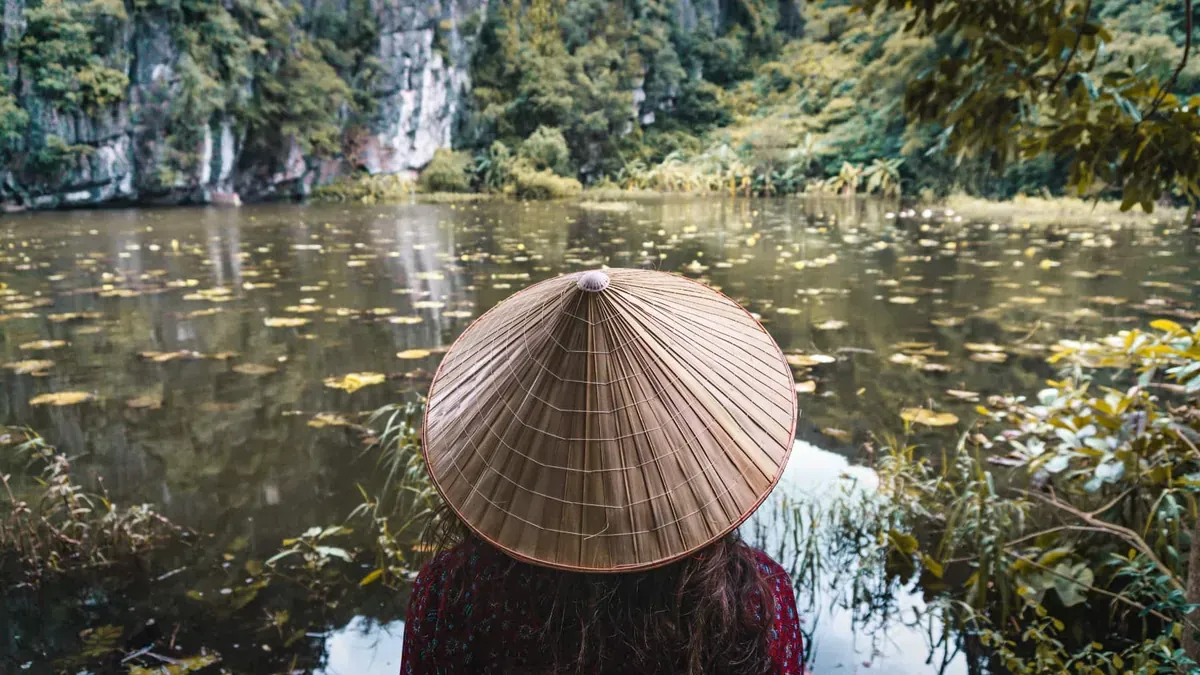 A person floats a canoe down a river in Southeast asia