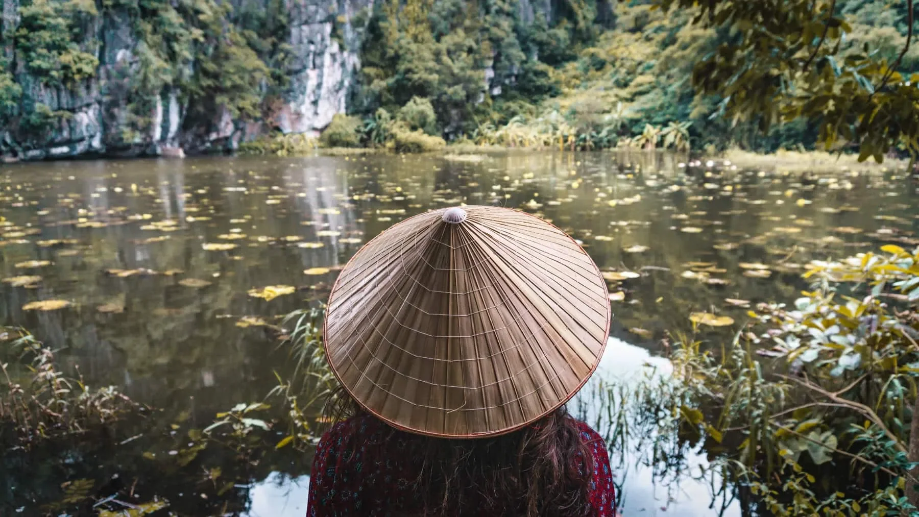 A person floats a canoe down a river in Southeast asia