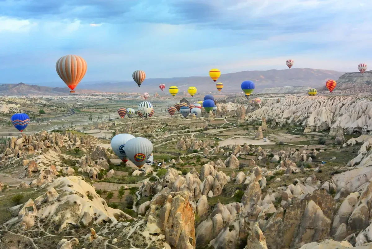 Hot air balloons sail over the rocky terrain of Turkey