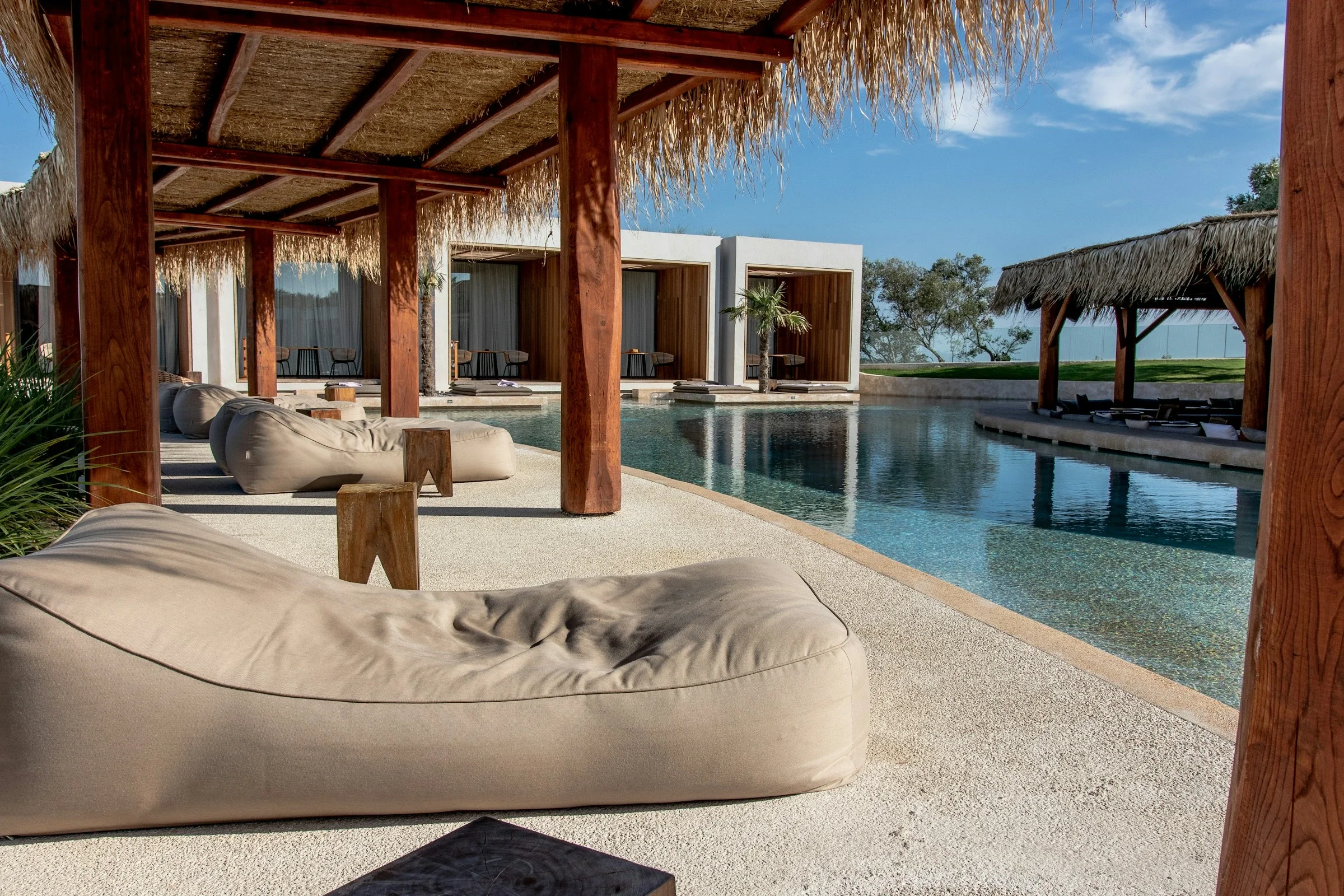 Thatched cabanas and loungers beside a resort pool