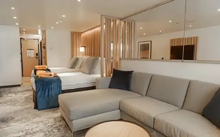 Quark Ultramarine Explorer Suite interior with large windows and queen bed