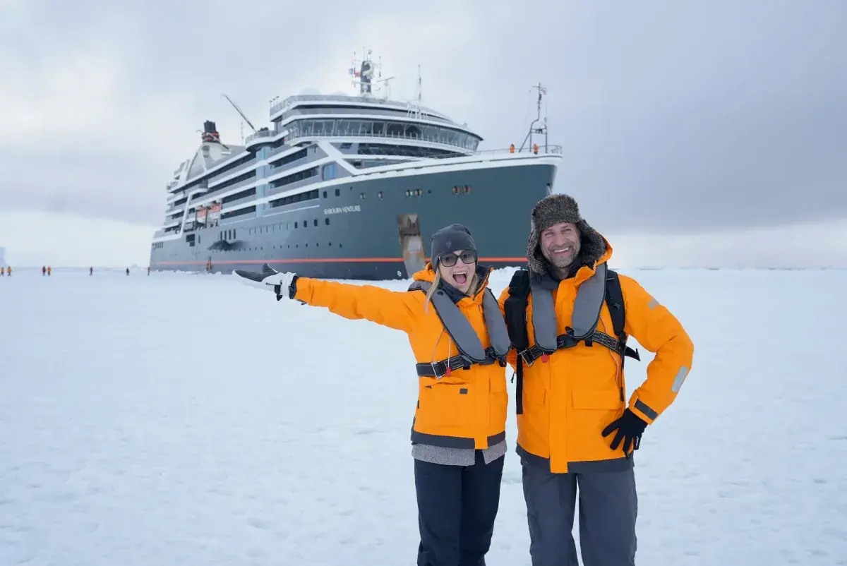 Phil and Erin Lockwood pose in front of the Seabourn Venture/Pursuit in Antarctica