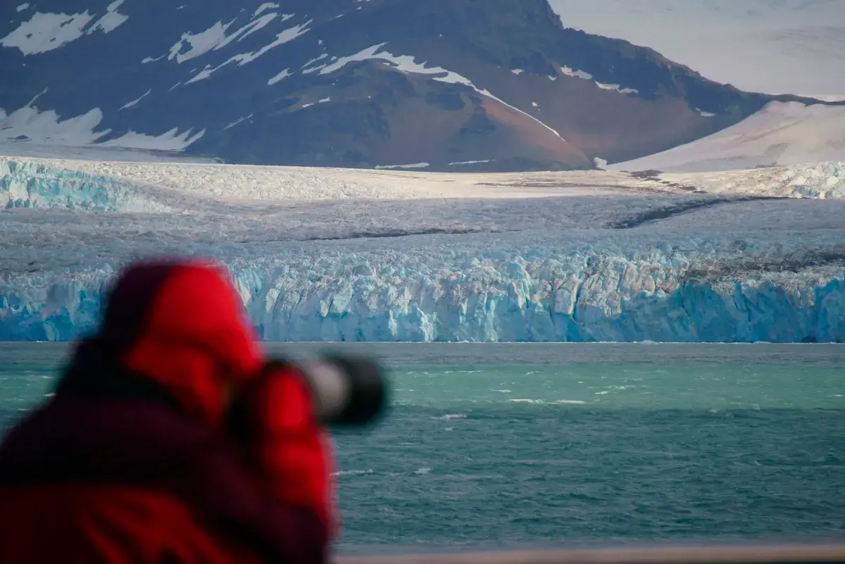 A cruise passenger takes photos of glaciers in Antarctica