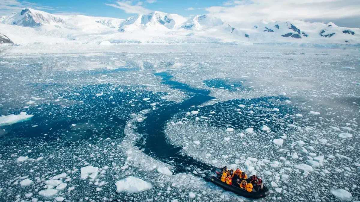 A zodiac sails through icy water