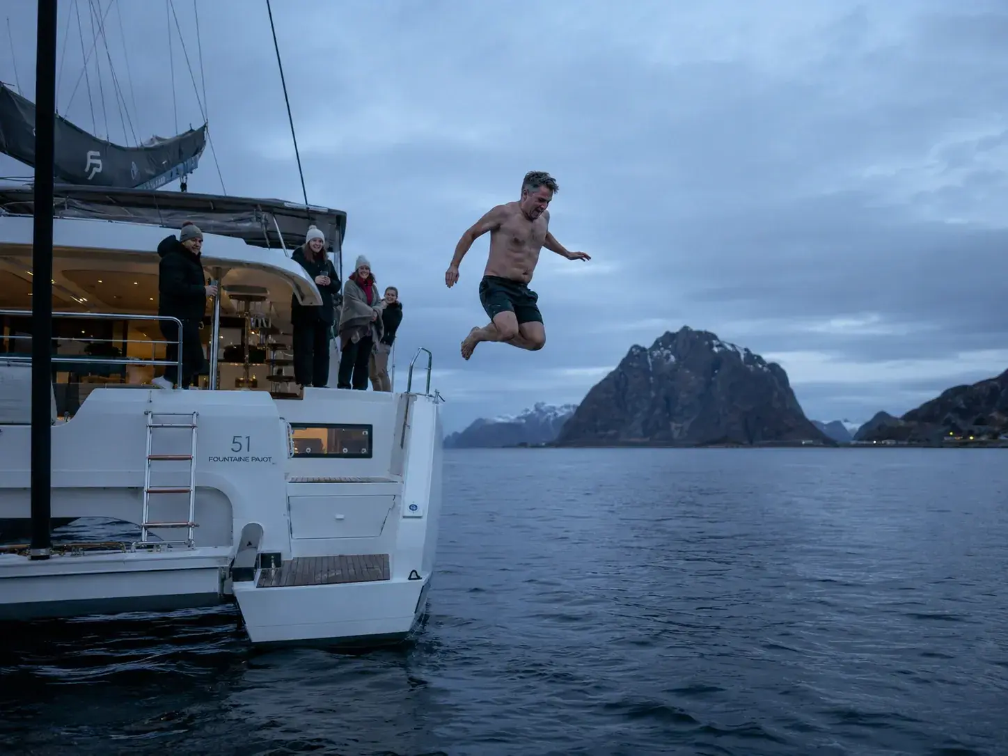Guest taking the polar plunge from the deck of the catamaran