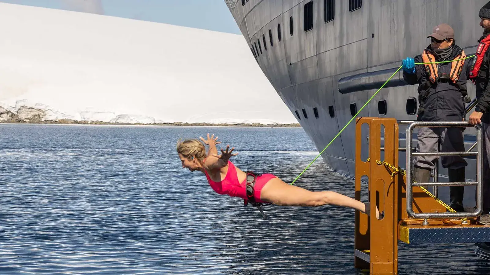 A woman takes the polar plunge off the Atlas Ocean Voyages World Navigator
