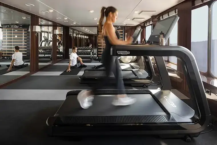 A woman runs on a treadmill in the Atlas World Navigator fitness center