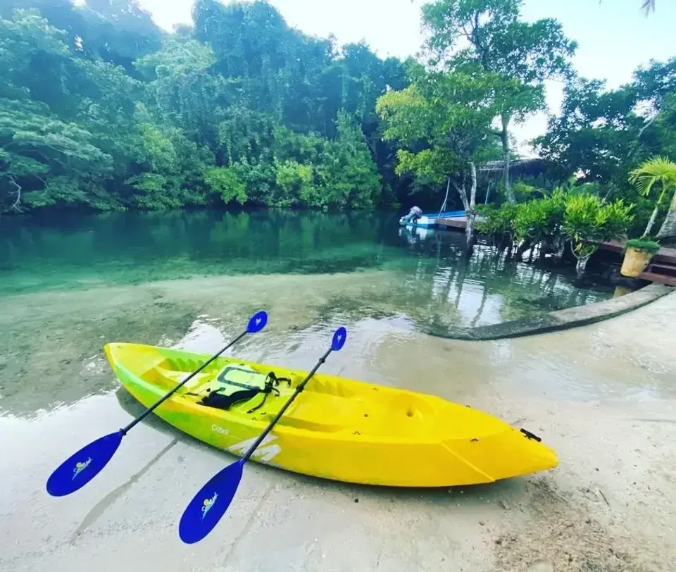 A kayak lies next to a lagoon in Fiji