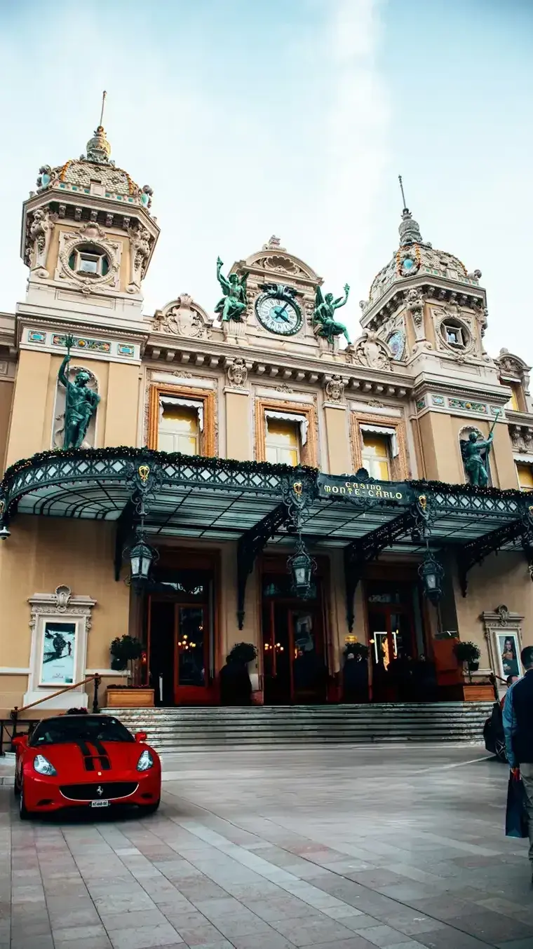 A Ferrari parked in front of a Monte Carlo casino