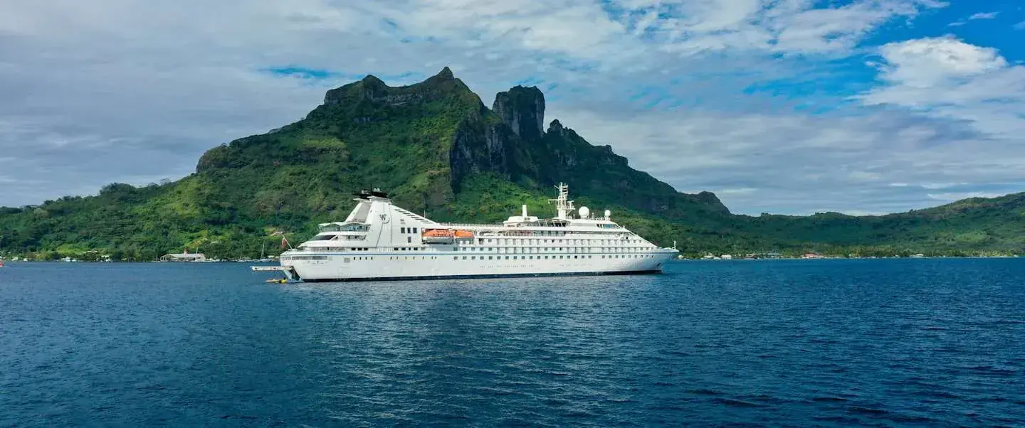 Windstar Star Breeze anchored in a pristine Tahitian bay, side view