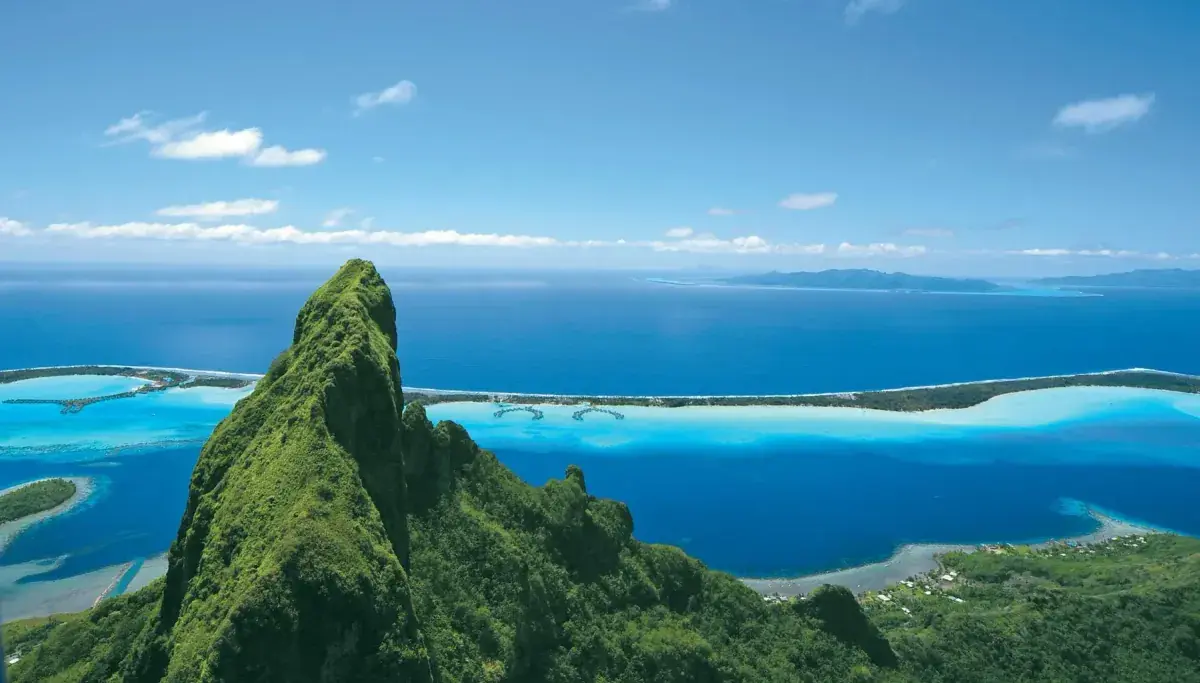 Aerial view of Tahiti's volcanic peaks and lush green shoreline