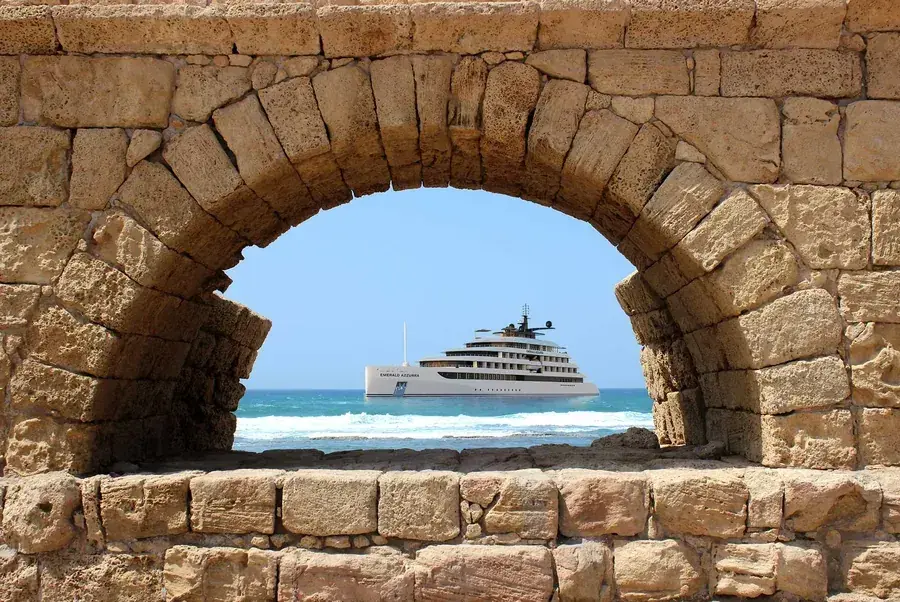 An Emerald Cruises luxury yacht through an arch in the Caesarea Aqueduct