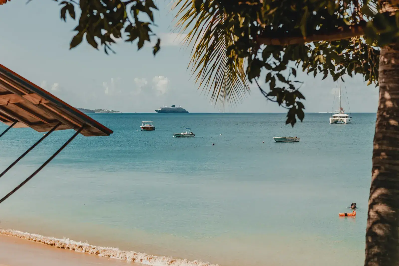 View of Caribbean beach with boats in the distance