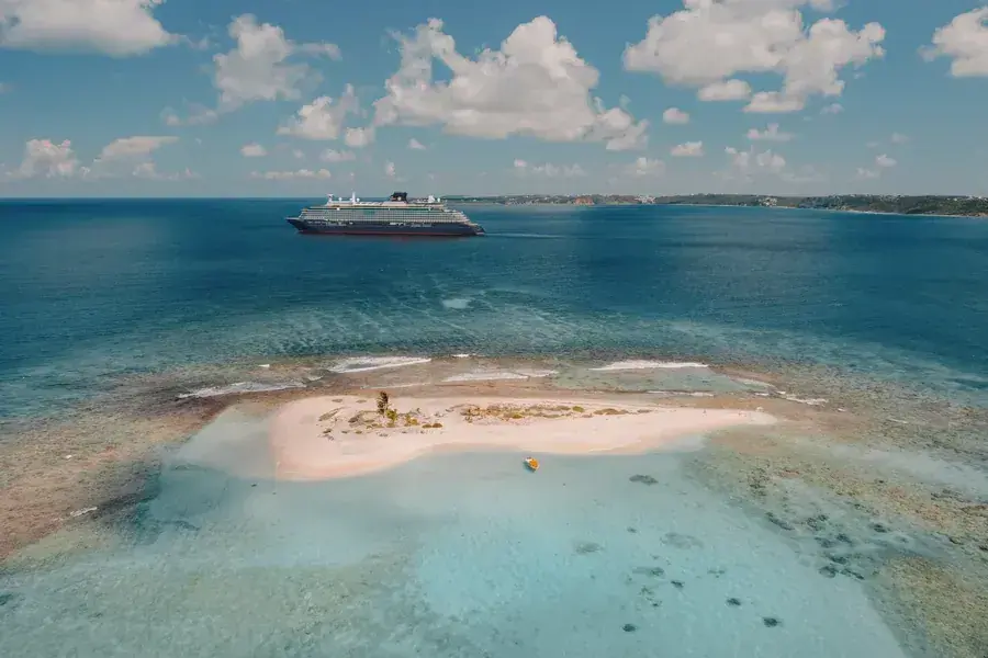 Aerial view of the Explora III cruise ship anchored off a reef island in the Caribbean