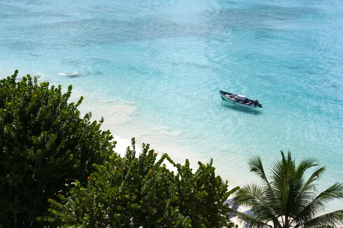 A small boat floats on Bridgetown Barbados beach