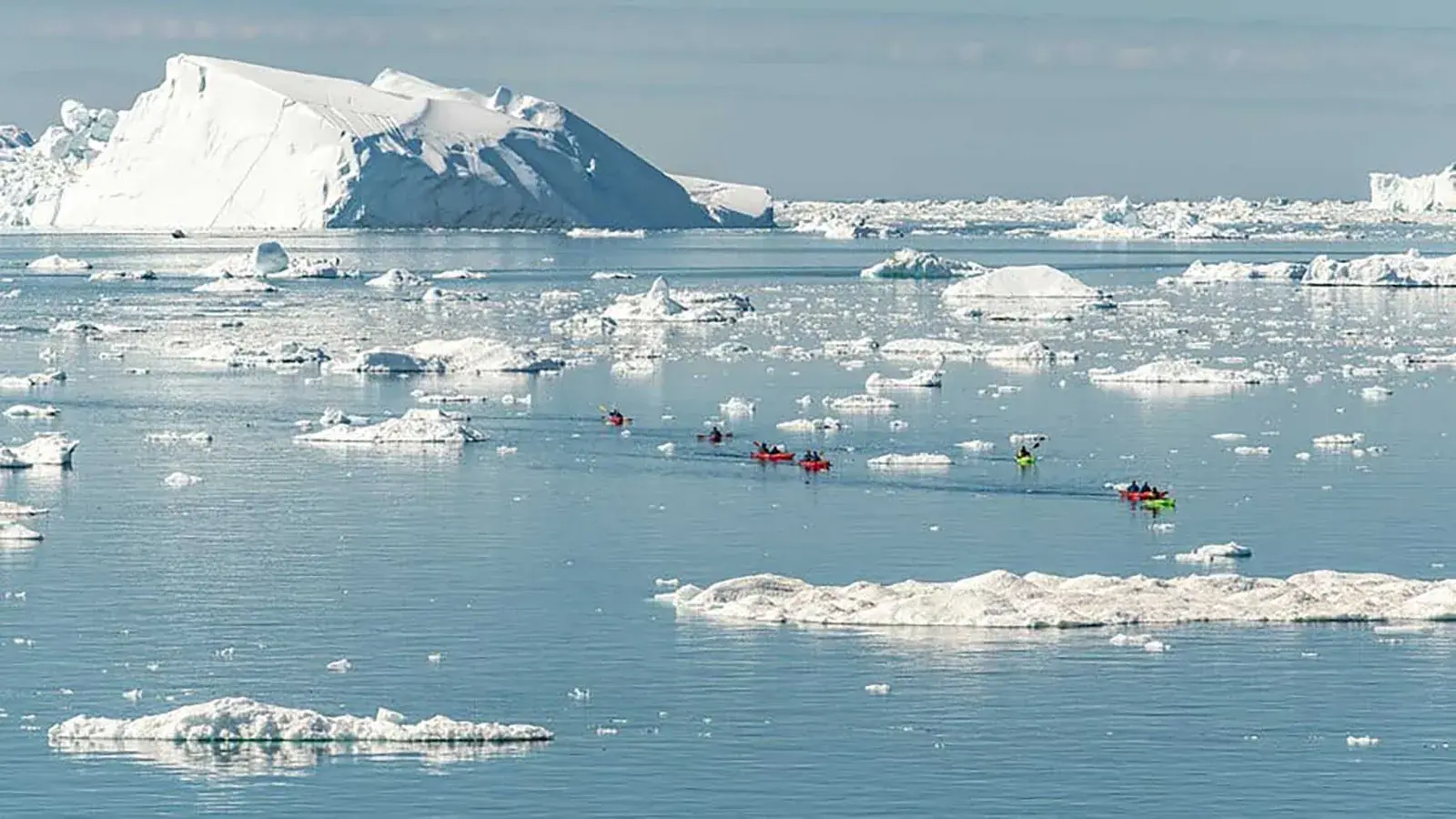 Kayakers in an icy Greenland harbor