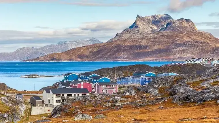Aerial view of a small Nuuk village and harbor in the background