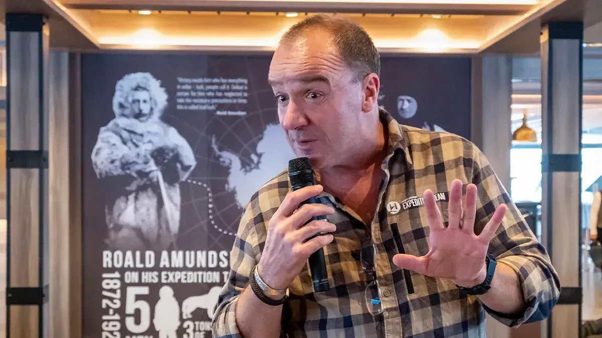 A guide gives a lecture on an HX Expedition cruise ship