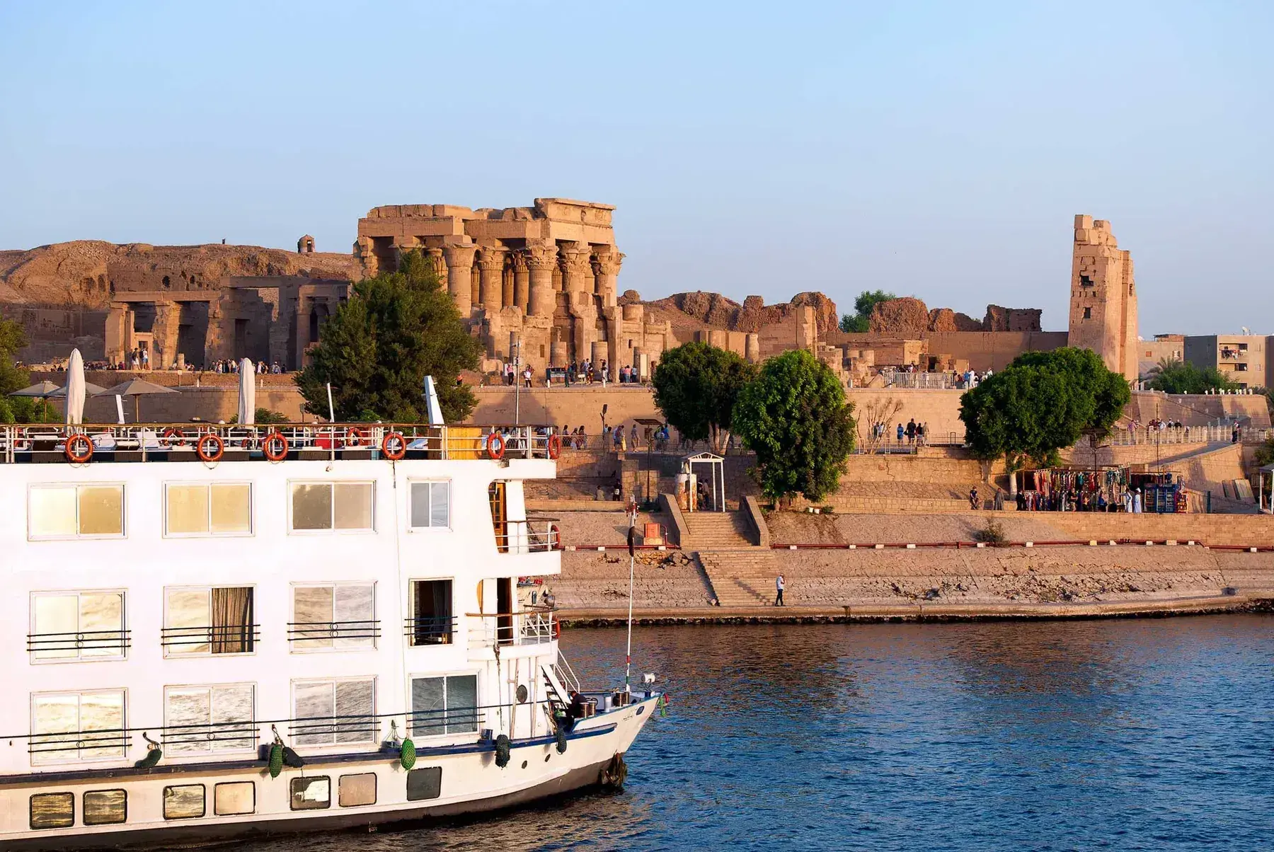 A Nile river cruise ship sails past ancient structures