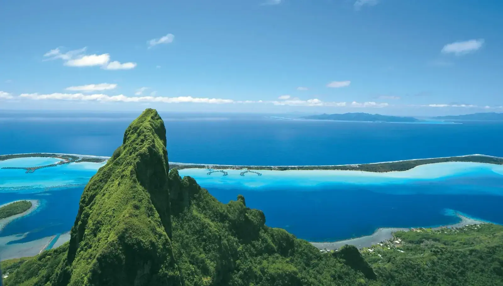 Aerial view of Tahiti's volcanic peaks and lush green shoreline