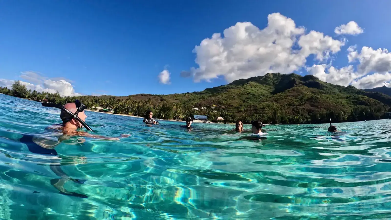 Snorkeler exploring the crystal-clear turquoise waters off Tahiti