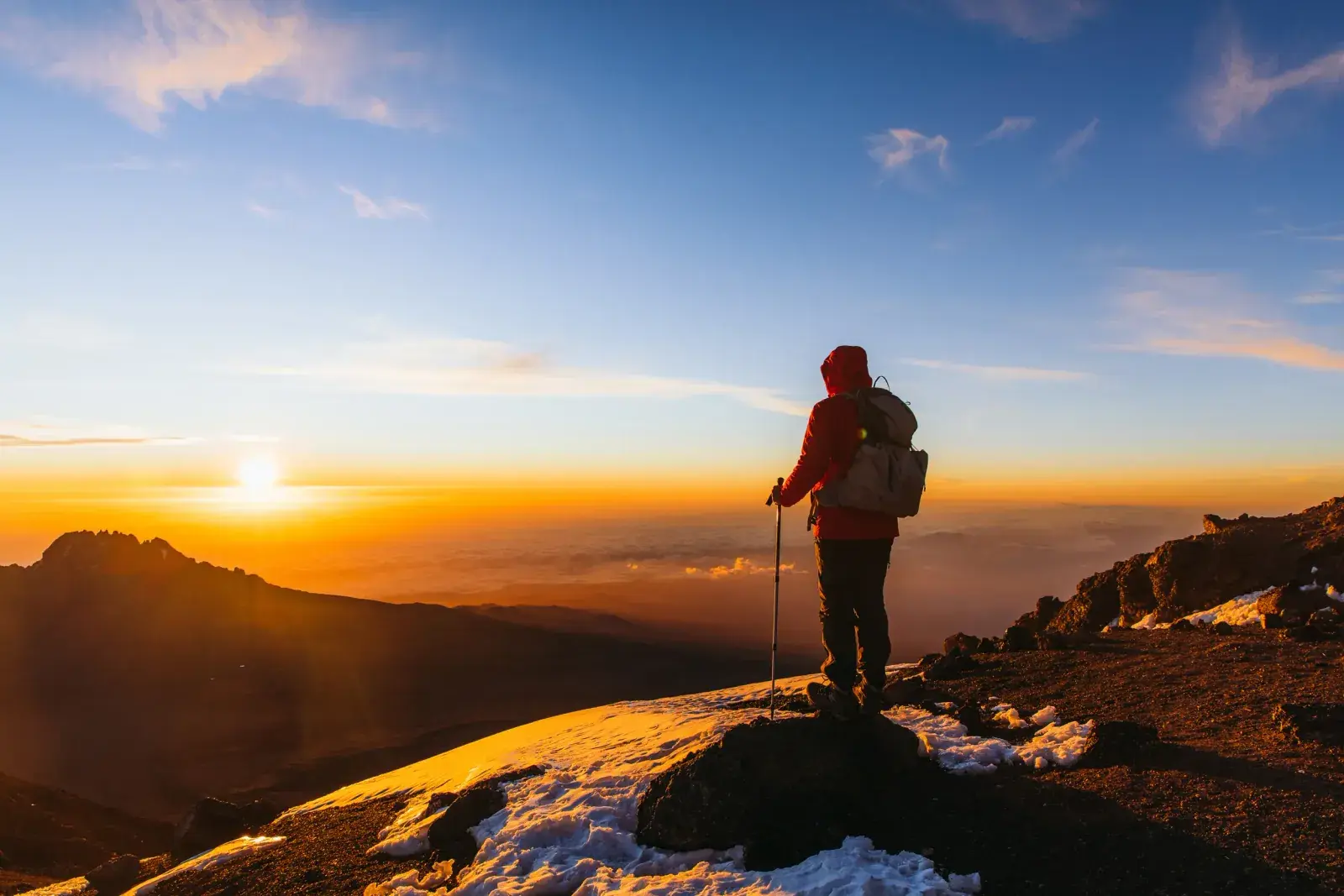 A lone hiker at the summit of Kilimanjaro at sunrise