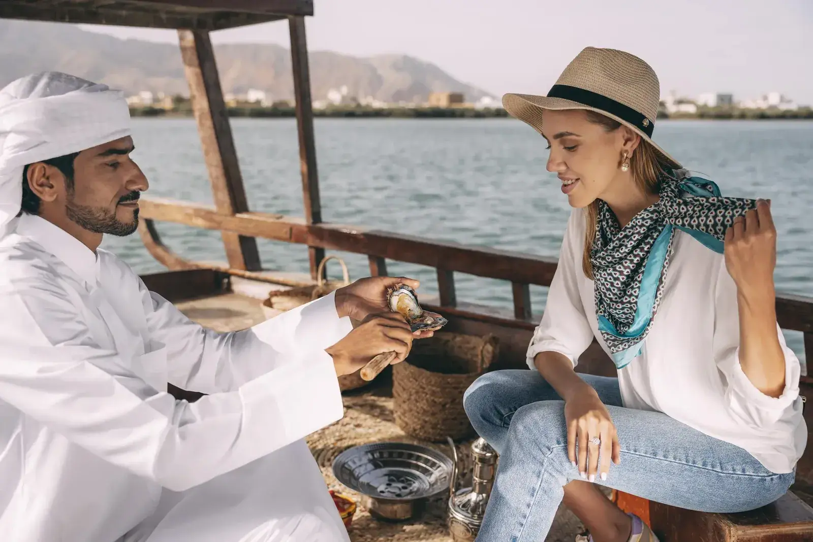 A woman looks at an open oyster at Suwaidi Pearl Farm