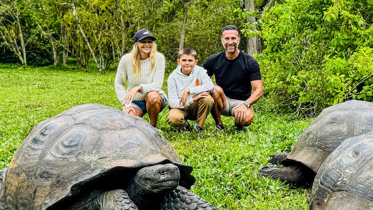 The Lockwood family kneels next to a giant tortoise