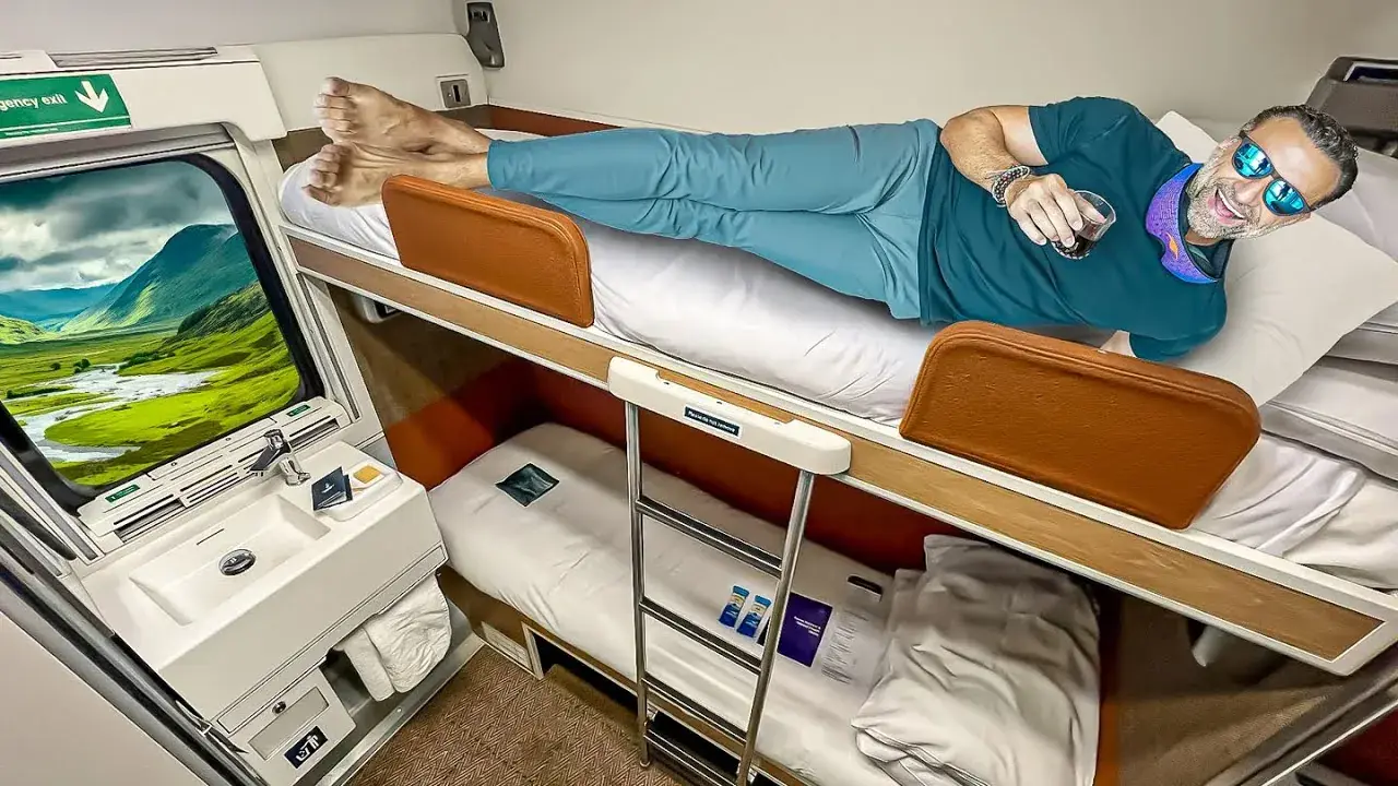 Phil Lockwood lying in a bedroom suite on a Scottish train